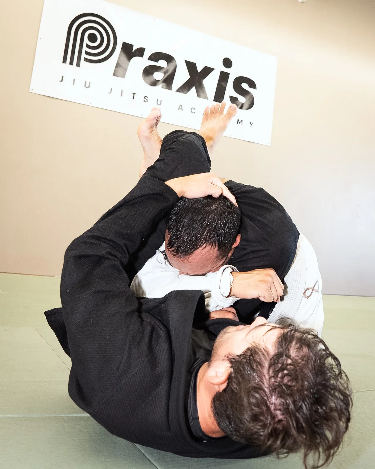 Adult students practicing a ground position in gis at Praxis