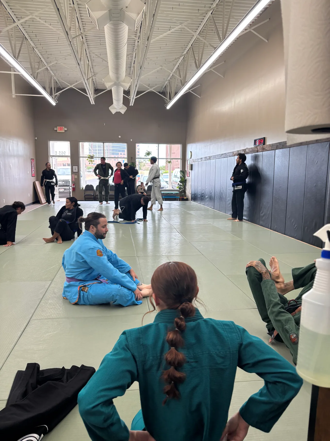 Adult students seated on the mats during class at Praxis