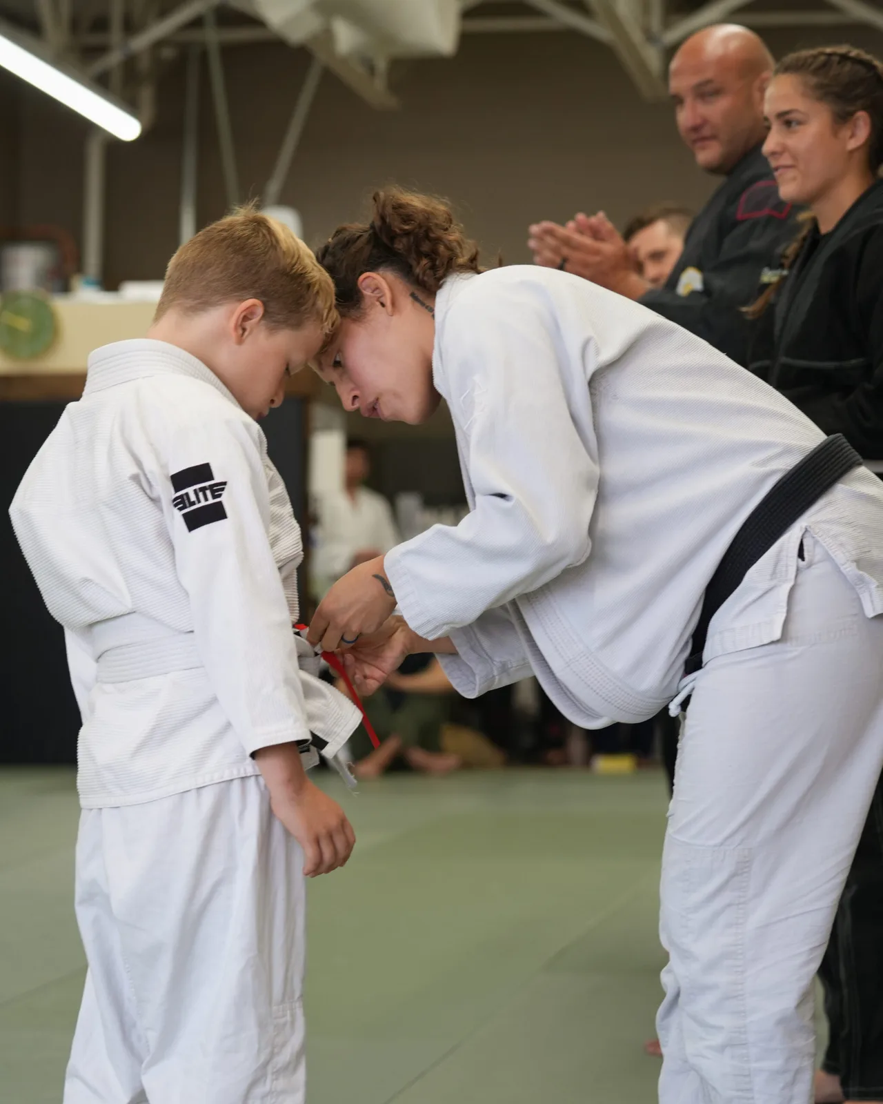 A coach helping a young student during kids class