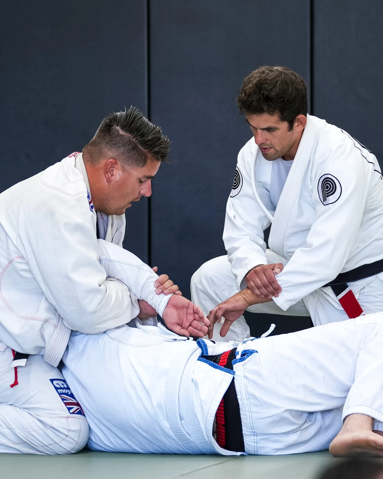 Two adult students practicing a Gi technique at Praxis